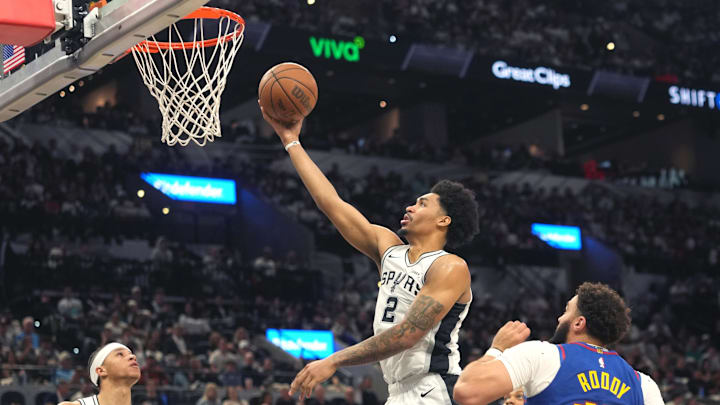 Apr 12, 2026; San Antonio, Texas, USA; San Antonio Spurs guard Dylan Harper (2) lays in a basket ahead of teammate forward Carter Bryant (11) and Denver Nuggets forward David Roddy (45) during the second half at Frost Bank Center. Mandatory Credit: Scott Wachter-Imagn Images