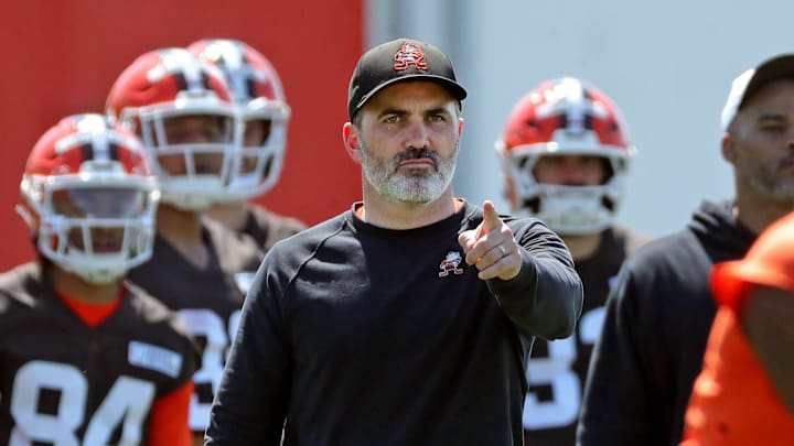 Cleveland Browns coach Kevin Stefanski watches quarterback Shedeur Sanders (12) participate in drills during day two of NFL rookie minicamp at the Cleveland Browns training facility May 10, 2025, in Berea, Ohio.