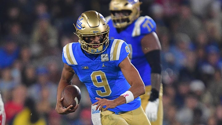 Nov 8, 2025; Pasadena, California, USA; UCLA Bruins quarterback Nico Iamaleava (9) runs the ball ahead of Nebraska Cornhuskers linebacker Dylan Rogers (52) during the first half at the Rose Bowl. Mandatory Credit: Gary A. Vasquez-Imagn Images