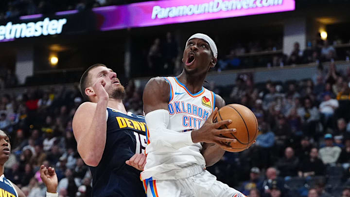 Nov 6, 2024; Denver, Colorado, USA; Oklahoma City Thunder guard Shai Gilgeous-Alexander (2) shoots the ball past Denver Nuggets center Nikola Jokic (15) in the second quarter at Ball Arena. Mandatory Credit: Ron Chenoy-Imagn Images