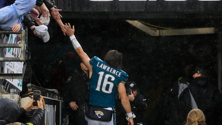 Jacksonville Jaguars quarterback Trevor Lawrence (16) high-fives a fan after the game of an NFL football game at EverBank Stadium, Sunday, Dec. 7, 2025, in Jacksonville, Fla. The Jaguars defeated the Colts 36-19.