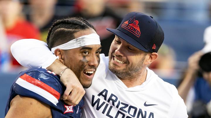Nov 8, 2025; Tucson, Arizona, USA; Arizona Wildcats quarterback Noah Fifita (1) celebrates with offensive coordinator Seth Doege after defeating the Kansas Jayhawks at Arizona Stadium. Mandatory Credit: Mark J. Rebilas-Imagn Images