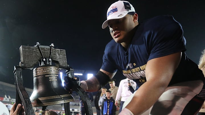 Jan 2, 2026; Memphis, TN, USA; Navy Midshipmen defensive lineman Landon Robinson (96) passes the Liberty Bell trophy off the stage after defeating the Cincinnati Bearcats in the Liberty Bowl at Simmons Bank Liberty Stadium. Mandatory Credit: Petre Thomas-Imagn Images