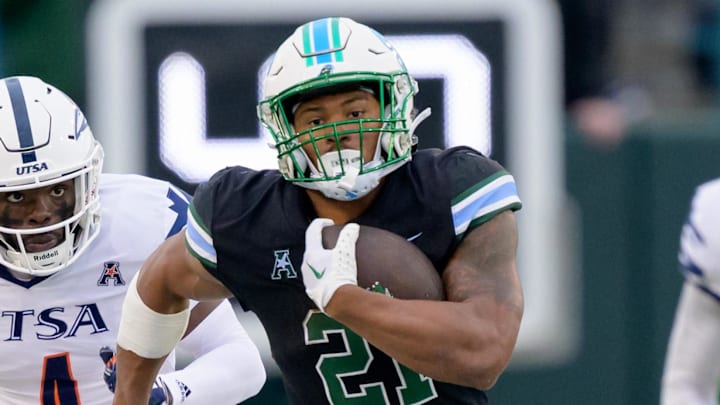 Nov 24, 2023; New Orleans, Louisiana, USA; Tulane Green Wave running back Makhi Hughes (21) runs against UTSA Roadrunners running back Kevorian Barnes (4) during the first half at Yulman Stadium Nov 24, 2023; New Orleans, Louisiana, USA; Tulane Green Wave running back Makhi Hughes (21) runs against UTSA Roadrunners running back Kevorian Barnes (4) during the first half at Yulman Stadium