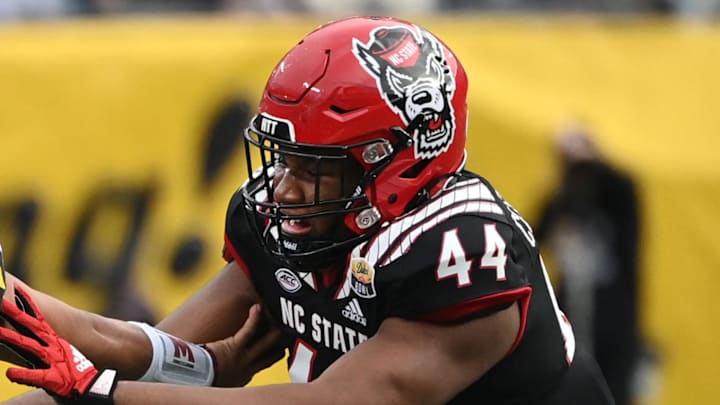 Dec 30, 2022; Charlotte, NC, USA; Maryland Terrapins quarterback Taulia Tagovailoa (3) scrambles as North Carolina State Wolfpack defensive lineman Brandon Cleveland (44) defends in the fourth quarter in the 2022 Duke's Mayo Bowl at Bank of America Stadium. Mandatory Credit: Bob Donnan-Imagn Images