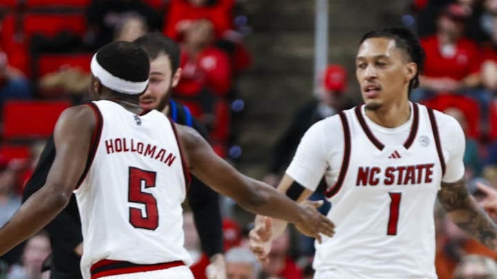Dec 6, 2025; Raleigh, North Carolina, USA; NC State Wolfpack guard Tre Holloman (5) high fives forward Ven-Allen Lubin (22) and forward Darrion Williams (1) during the second half of the game against UNC Asheville Bulldogs at Lenovo Center. Mandatory Credit: Jaylynn Nash-Imagn Images Dec 6, 2025; Raleigh, North Carolina, USA; NC State Wolfpack guard Tre Holloman (5) high fives forward Ven-Allen Lubin (22) and forward Darrion Williams (1) during the second half of the game against UNC Asheville Bulldogs at Lenovo Center. Mandatory Credit: Jaylynn Nash-Imagn Images