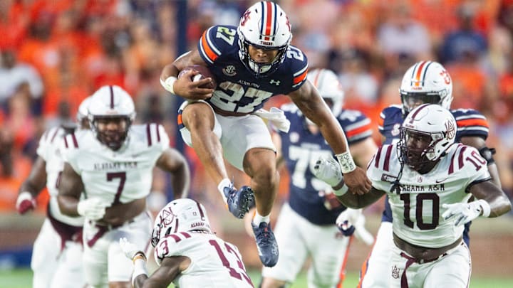 Auburn Tigers running back Jarquez Hunter (27) hurdles Alabama A&M Bulldogs defensive back Elijah Eberhardt (13) as Auburn Tigers takes on Alabama A&M Bulldogs at Jordan-Hare Stadium in Auburn, Ala., on Saturday, Aug. 31, 2024.