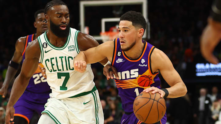 Dec 7, 2022; Phoenix, Arizona, USA; Boston Celtics guard Jaylen Brown (7) defends against Phoenix Suns guard Devin Booker (1) at Footprint Center. Mandatory Credit: Mark J. Rebilas-Imagn Images