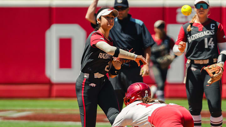 Arkansas Razorbacks Atalyia Rijo completes throw to first base against the Oklahoma Sooners.