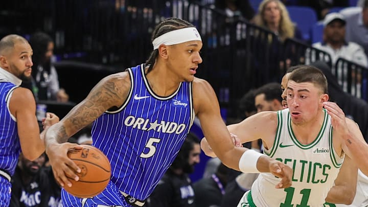 Nov 9, 2025; Orlando, Florida, USA; Orlando Magic forward Paolo Banchero (5) drives around Boston Celtics guard Payton Pritchard (11) during the first quarter at Kia Center. Mandatory Credit: Mike Watters-Imagn Images
