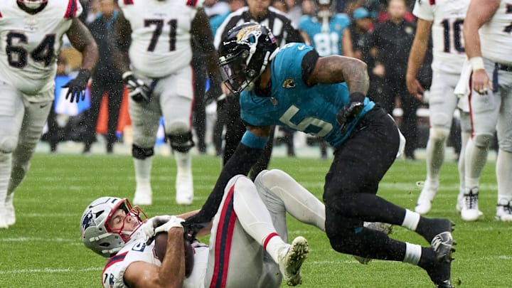 Oct 20, 2024; London, United Kingdom; New England Patriots tight end Hunter Henry (85) is tackled by Jacksonville Jaguars safety Andre Cisco (5) in the first half during an NFL International Series game at Wembley Stadium. Mandatory Credit: Peter van den Berg-Imagn Images