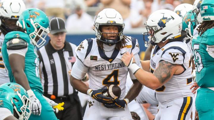 Sep 5, 2026; Morgantown, West Virginia, USA; West Virginia Mountaineers running back Cam Cook (4) runs for a touchdown during the second quarter against the Coastal Carolina Chanticleers at Milan Puskar Stadium. Mandatory Credit: Ben Queen-Imagn Images Sep 5, 2026; Morgantown, West Virginia, USA; West Virginia Mountaineers running back Cam Cook (4) runs for a touchdown during the second quarter against the Coastal Carolina Chanticleers at Milan Puskar Stadium. Mandatory Credit: Ben Queen-Imagn Images