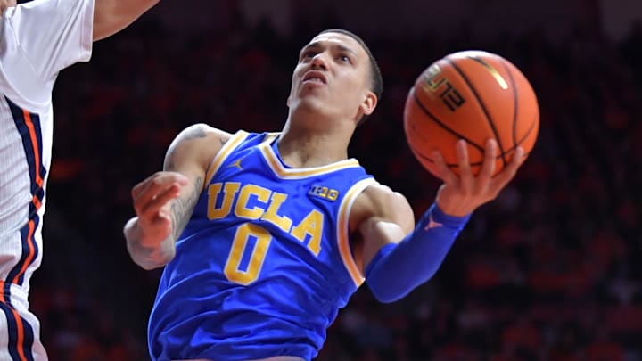 Feb 11, 2025; Champaign, Illinois, USA;  UCLA Bruins guard Kobe Johnson (0) drives to the basket as Illinois Fighting Illini forward Will Riley (7) defends during the second half at State Farm Center. Mandatory Credit: Ron Johnson-Imagn Images