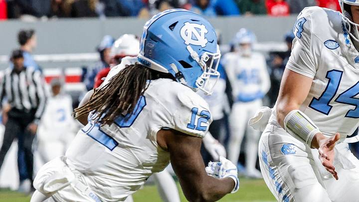 Nov 29, 2025; Raleigh, North Carolina, USA; North Carolina Tar Heels quarterback Max Johnson (14) passes the ball to running back Demon June (12) during the second half of the game against NC State Wolfpack at Carter-Finley Stadium. Mandatory Credit: Jaylynn Nash-Imagn Images Nov 29, 2025; Raleigh, North Carolina, USA; North Carolina Tar Heels quarterback Max Johnson (14) passes the ball to running back Demon June (12) during the second half of the game against NC State Wolfpack at Carter-Finley Stadium. Mandatory Credit: Jaylynn Nash-Imagn Images