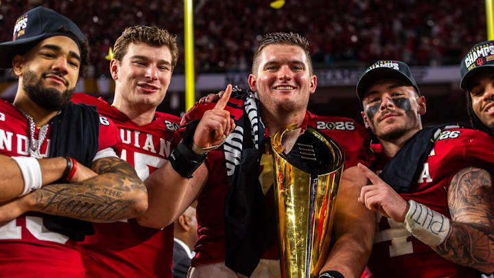 Indiana's Elijah Sarratt (13), Fernando Mendoza (15), Pat Coogan (78), Aiden Fisher (4) and Riley Nowakowski (37) pose with the trophy on the podium after the College Football Playoff National Championship college football game at Hard Rock Stadium in Miami Gardens on Monday, Jan. 19, 2026.