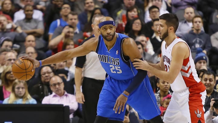 Jan 22, 2014; Toronto, Ontario, CAN; Dallas Mavericks guard-forward Vince Carter (25) keeps the ball away from Toronto Raptors guard Greivis Vasquez (21)  during the first half at the Air Canada Centre. Mandatory Credit: John E. Sokolowski-Imagn Images