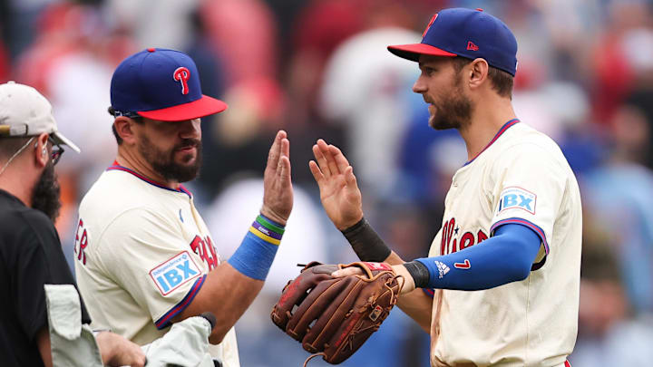 Philadelphia Phillies designated hitter Kyle Schwarber (12) and shortstop Trea Turner (7) high five after a victory against the Seattle Mariners at Citizens Bank Park.