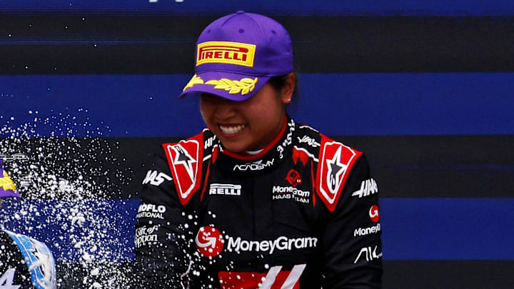 May 4, 2024; Miami Gardens, Florida, USA; F1 Academy driver Chloe Chambers (14) celebrates with F1 Academy driver Abbi Pulling (9) on the podium after the F1 Academy First Race at Miami International Autodrome. Pulling won first place and Chambers won third place. Mandatory Credit: Peter Casey-Imagn Images