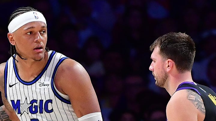 Feb 24, 2026; Los Angeles, California, USA; Orlando Magic forward Paolo Banchero (5) moves the ball against Los Angeles Lakers guard Luka Doncic (77)  during the second half at Crypto.com Arena. Mandatory Credit: Gary A. Vasquez-Imagn Images