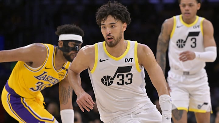 Feb 10, 2025; Los Angeles, California, USA; Utah Jazz guard Johnny Juzang (33) controls the ball around Los Angeles Lakers guard Jordan Goodwin (30) in the second half at Crypto.com Arena. Mandatory Credit: Jayne Kamin-Oncea-Imagn Images