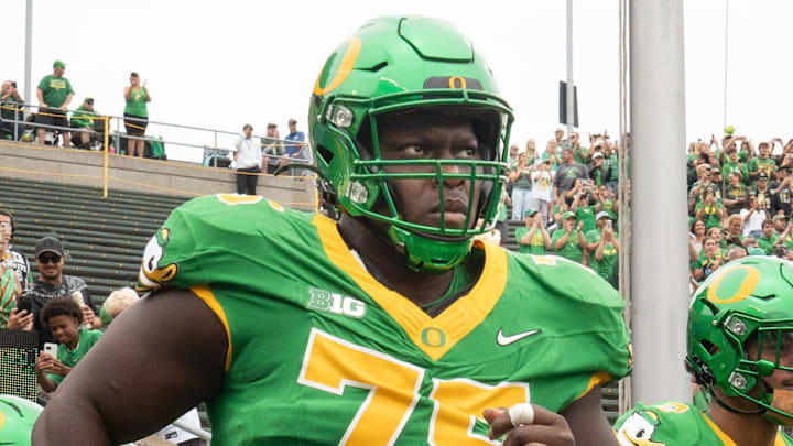 Oregon’s Emmanuel Pregnon, center, takes the field before the game against Oklahoma State at Autzen.
