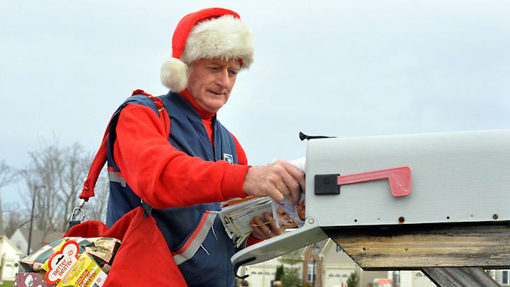 A mail carrier during Christmastime dressed up in festive gear A mail carrier during Christmastime dressed up in festive gear