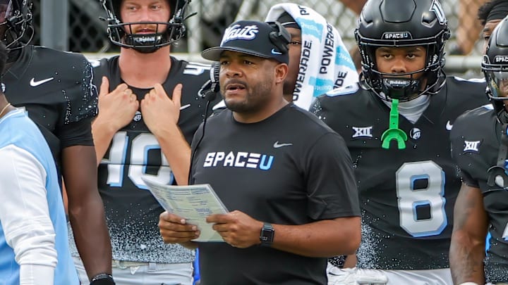 Nov 2, 2024; Orlando, Florida, USA; UCF Knights assistant coach Tim Harris Jr (middle) calls a play during the first quarter against the Arizona Wildcats at FBC Mortgage Stadium. Mandatory Credit: Mike Watters-Imagn Images