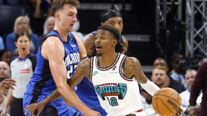 Oct 26, 2024; Memphis, Tennessee, USA; Memphis Grizzlies guard Ja Morant (12) dribbles as Orlando Magic guard Kentavious Caldwell-Pope (3) and forward Franz Wagner (22) defend during the first half at FedExForum. Mandatory Credit: Petre Thomas-Imagn Images