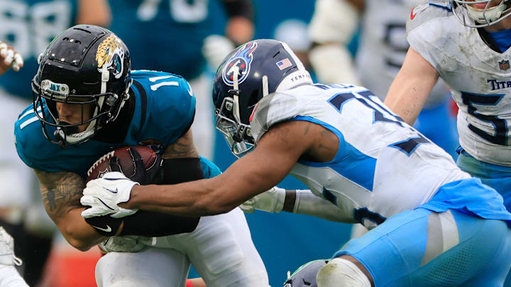 Jacksonville Jaguars wide receiver Parker Washington (11) rushes for yards against Tennessee Titans safety Mike Brown (44), bottom, and cornerback Daryl Worley (35) during the fourth quarter Sunday, Dec. 29, 2024 at EverBank Stadium in Jacksonville, Fla. The Jaguars held off the Titans 20-13. [Corey Perrine/Florida Times-Union]
