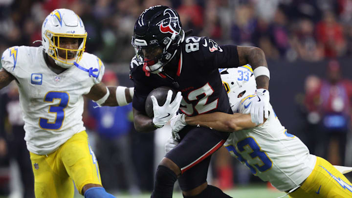 Jan 11, 2025; Houston, Texas, USA; Houston Texans wide receiver Diontae Johnson (82) runs the ball after a reception against Los Angeles Chargers defensive back Deane Leonard (33) and safety Derwin Jarnes Jr. (3) during the third quarter in an AFC wild card game at NRG Stadium. Mandatory Credit: Troy Taormina-Imagn Images Jan 11, 2025; Houston, Texas, USA; Houston Texans wide receiver Diontae Johnson (82) runs the ball after a reception against Los Angeles Chargers defensive back Deane Leonard (33) and safety Derwin Jarnes Jr. (3) during the third quarter in an AFC wild card game at NRG Stadium. Mandatory Credit: Troy Taormina-Imagn Images