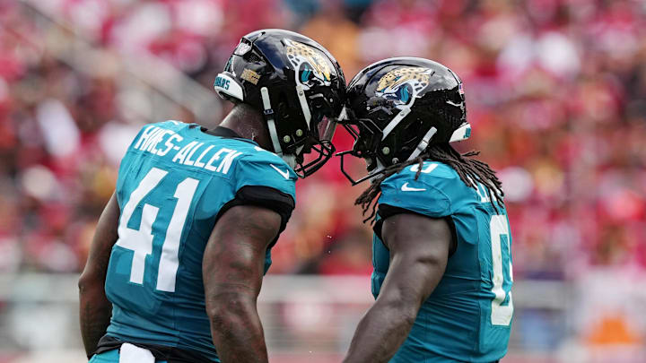 Sep 28, 2025; Santa Clara, California, USA; Jacksonville Jaguars running back Travis Etienne Jr. (1) celebrates after scoring a touchdown with Jacksonville Jaguars defensive end Josh Hines-Allen (41) during the second half against the San Francisco 49ers at Levi's Stadium. Mandatory Credit: Darren Yamashita-Imagn Images