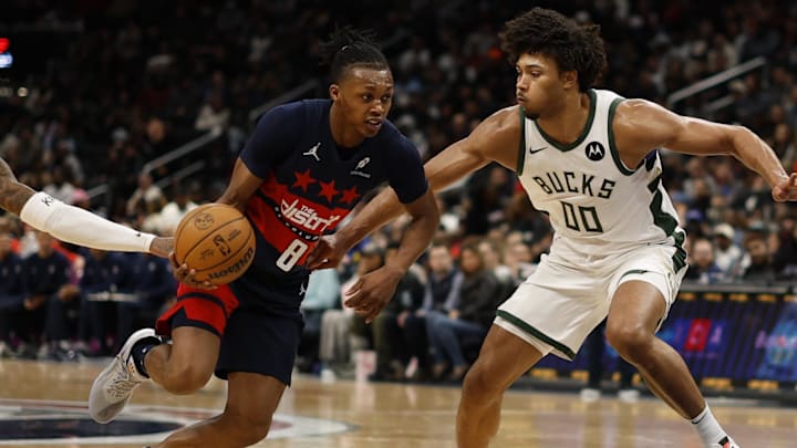Feb 21, 2025; Washington, District of Columbia, USA; Washington Wizards guard Bub Carrington (8) drives to the basket as Milwaukee Bucks guard Kevin Porter Jr. (3) and Bucks center Jericho Sims (00) defend in the second half at Capital One Arena. Mandatory Credit: Geoff Burke-Imagn Images