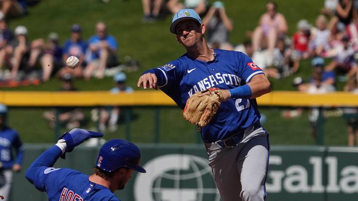 Mar 11, 2026; Mesa, Arizona, USA; Kansas City Royals shortstop Kevin Newman (27) turns a double play over Chicago Cubs second baseman Nico Hoerner (2) in the first inning at Sloan Park. Mandatory Credit: Rick Scuteri-Imagn Images