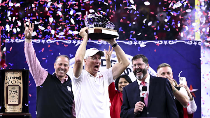 Houston Cougars head coach Willie Fritz hoists the Texas Bowl trophy after the win over Louisiana State Tigers at NRG Stadium. Mandatory Credit: Maria Lysaker-Imagn Images 