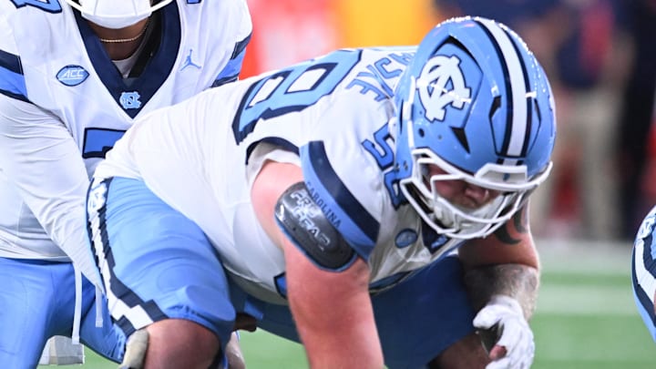 Oct 31, 2025; Syracuse, New York, USA; North Carolina Tar Heels quarterback Gio Lopez (7) with center Austin Blaske (58) at the line of scrimmage in the third quarter against the Syracuse Orange at the JMA Wireless Dome. Mandatory Credit: Mark Konezny-Imagn Images