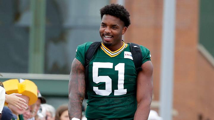 Green Bay Packers defensive end Dani Dennis-Sutton (51) greets fans while participating in the DreamDrive bicycle ride during the third day of training camp on July 31, 2026, in Green Bay, Wis.