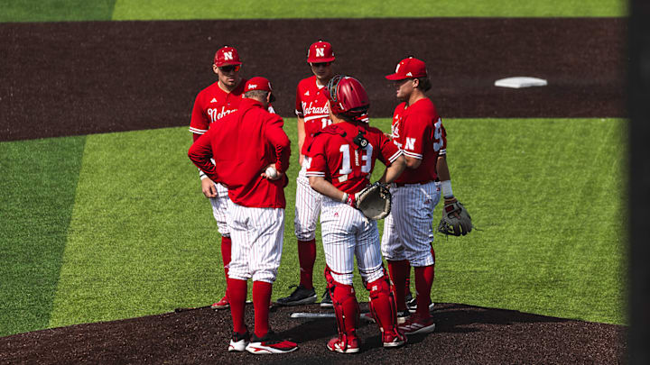 Nebraska baseball infielders meet on the mound Saturday against Iowa.