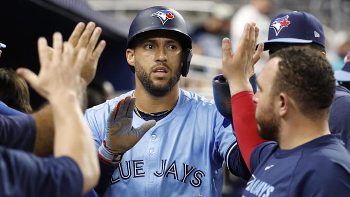 Toronto Blue Jays right fielder George Springer (4) celebrates in the dugout with teammates after scoring  against the Miami Marlins during the 12th inning at loanDepot Park. 
