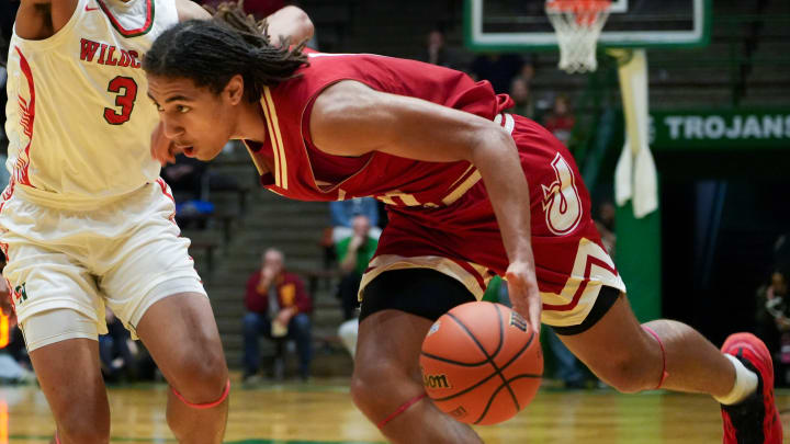 Jeffersonville Red Devils Tre Singleton (0) drives the lane as Lawrence North Wildcats Brennan Miller (3) defends, Saturday, March 16, 2024, during the IHSAA Class 4A semistate game at New Castle High School in Newcastle, Indiana. The Jeffersonville Red Devils defeated the Lawrence North Wildcats, 62-60.