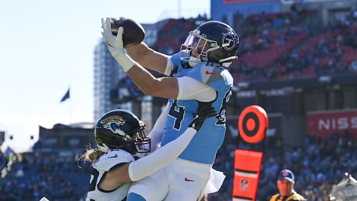 Nov 30, 2025; Nashville, Tennessee, USA; Jacksonville Jaguars safety Andrew Wingard (42) breaks up the pass to Tennessee Titans tight end Gunnar Helm (84) during the first half at Nissan Stadium. Mandatory Credit: Steve Roberts-Imagn Images