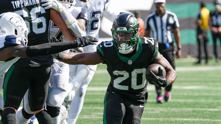 Oct 5, 2025; East Rutherford, New Jersey, USA; New York Jets running back Breece Hall (20) carries the ball as he works around Dallas Cowboys safety Donovan Wilson (6) during the first half at MetLife Stadium. Mandatory Credit: Robert Deutsch-Imagn Images