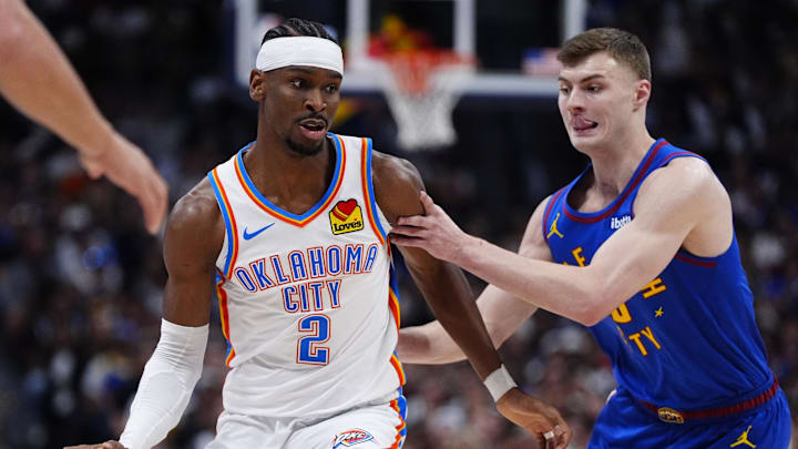 May 9, 2025; Denver, Colorado, USA; Denver Nuggets guard Christian Braun (0) defends Oklahoma City Thunder guard Shai Gilgeous-Alexander (2) in the first quarter during game three of the second round for the 2025 NBA Playoffs at Ball Arena. Mandatory Credit: Ron Chenoy-Imagn Images