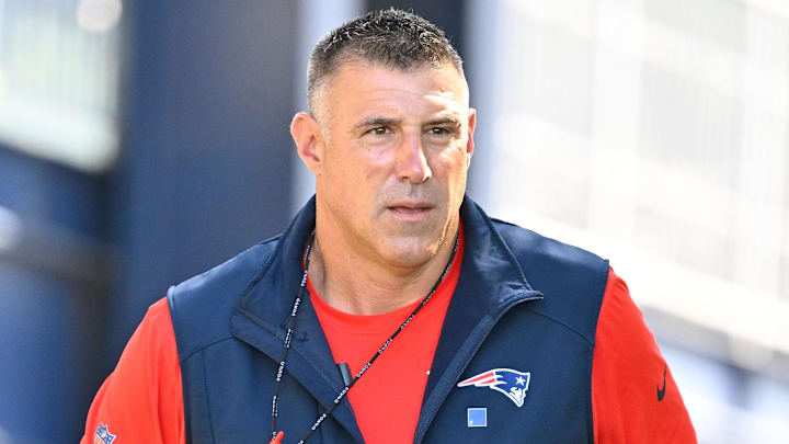Jul 23, 2025; Foxborough, MA, USA; New England Patriots head coach Mike Vrabel delivers a puppy to a local family as part of the Patriots pet adoption event before the start of training camp at Gillette Stadium. Mandatory Credit: Eric Canha-Imagn Images