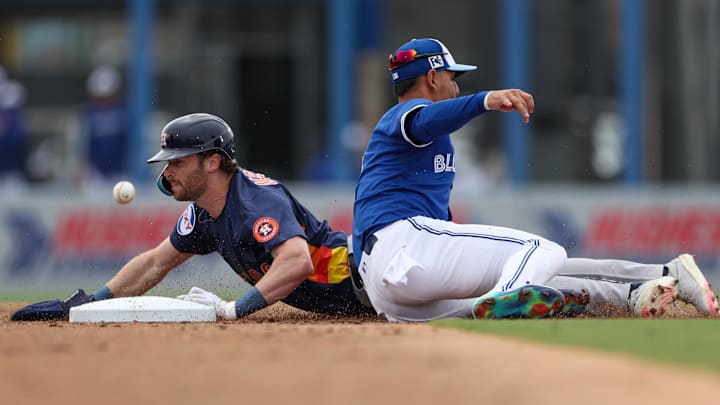 Mar 10, 2025; Dunedin, Florida, USA; Houston Astros outfielder Jacob Melton (76) steals second base past Toronto Blue Jays second baseman Andres Gimenez (0) in the second inning during spring training at TD Ballpark. 