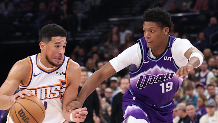 Oct 27, 2025; Salt Lake City, Utah, USA; Phoenix Suns guard Devin Booker (1) drives against Utah Jazz guard Ace Bailey (19) during the first quarter at Delta Center. Mandatory Credit: Rob Gray-Imagn Images