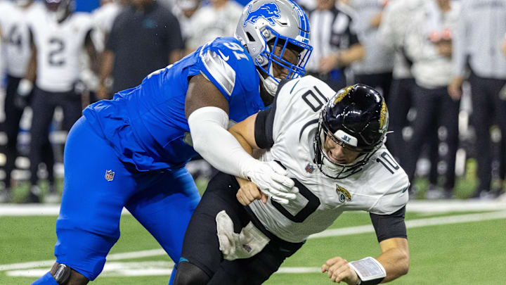 Nov 17, 2024; Detroit, Michigan, USA; Jacksonville Jaguars quarterback Mac Jones (10) passes the ball and is pressured by Detroit Lions defensive end Levi Onwuzurike (91) during the second half at Ford Field. Mandatory Credit: David Reginek-Imagn Images