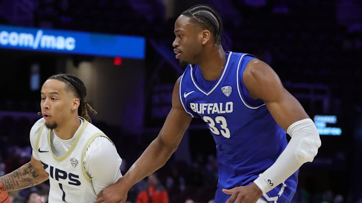 Akron Zips guard Shammah Scott (1) drives ahead of Buffalo Bulls center Tim Oboh (33) during the first half of an NCAA college basketball game in the quarterfinals of the MAC Basketball Tournament at Rocket Arena, March 12, 2026, in Cleveland, Ohio.