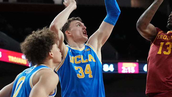 Mar 7, 2026; Los Angeles, California, USA; Southern California Trojans guard Kam Woods (13) shoots the ball against UCLA Bruins guard Trent Perry (0), forward Tyler Bilodeau (34) and forward Eric Dailey Jr. (3) in the second half at Galen Center. Mandatory Credit: Kirby Lee-Imagn Images Mar 7, 2026; Los Angeles, California, USA; Southern California Trojans guard Kam Woods (13) shoots the ball against UCLA Bruins guard Trent Perry (0), forward Tyler Bilodeau (34) and forward Eric Dailey Jr. (3) in the second half at Galen Center. Mandatory Credit: Kirby Lee-Imagn Images