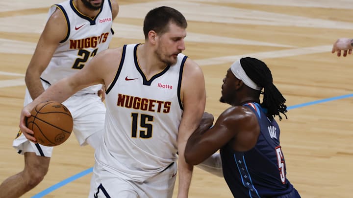 Feb 27, 2026; Oklahoma City, Oklahoma, USA; Denver Nuggets center Nikola Jokić (15) drives against Oklahoma City Thunder guard Luguentz Dort (5) during the second quarter at Paycom Center.