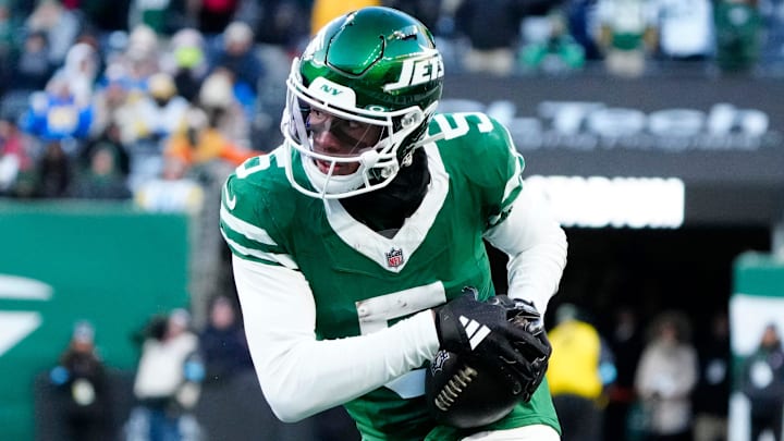 New York Jets wide receiver Garrett Wilson (5) runs with the ball after completing a pass as he approaches Los Angeles Rams safety Jaylen McCollough (39), Sunday, December 22, 2024, in East Rutherford.